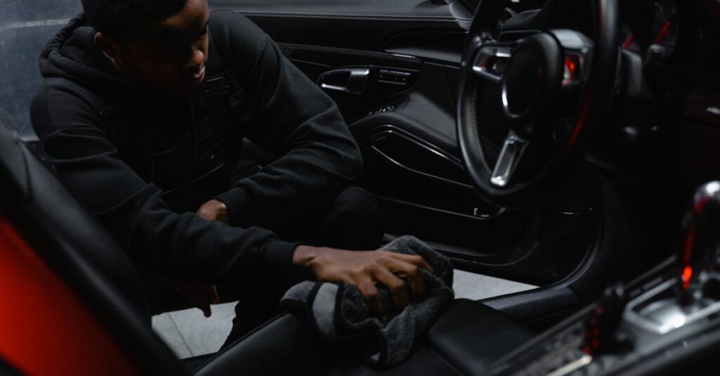 A man wipes the interior of a car for a thorough cleaning, focusing on detailing and maintenance.